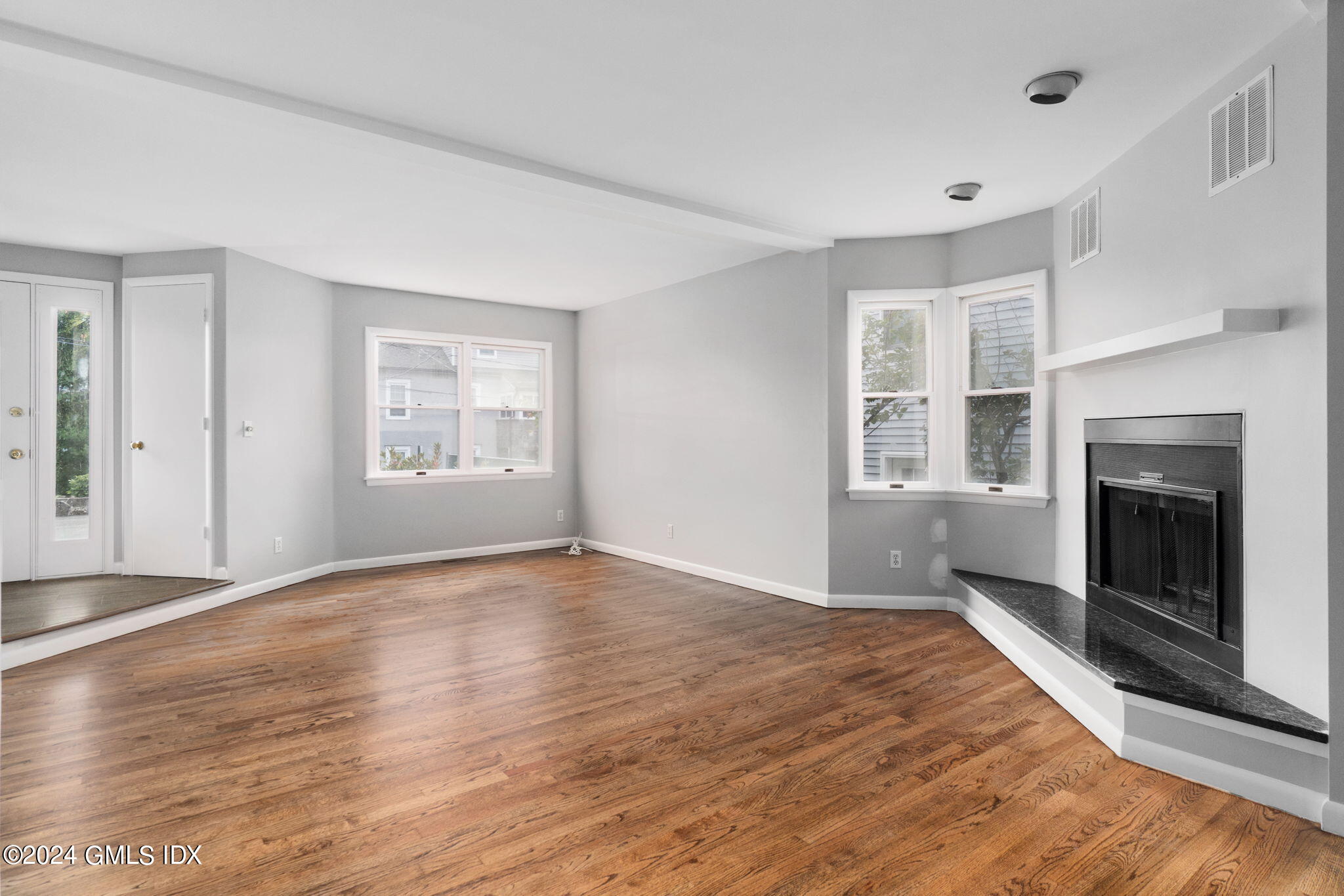 10 Tulip Street, Unit A Cos Cob, CT 06807 - Photo 7 of 27 a view of empty room with wooden floor and fireplace