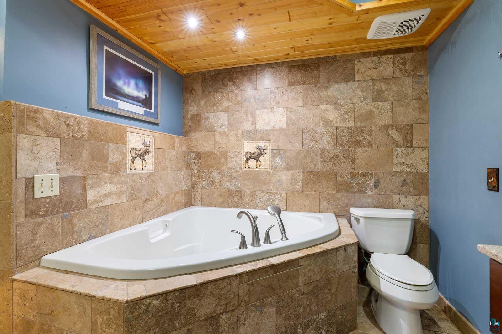 12957 West Ridge Road Ely, MN 55731 - Photo 23 of 41 Full bathroom featuring toilet, wood ceiling, a garden tub, and visible vents