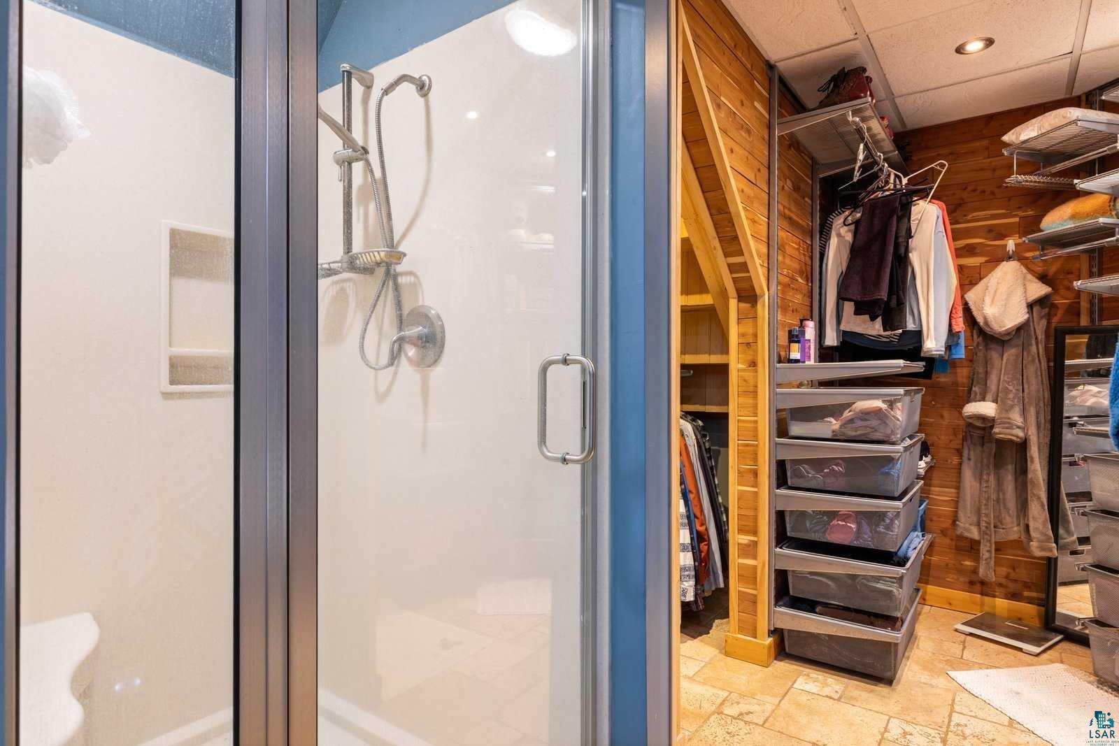 12957 West Ridge Road Ely, MN 55731 - Photo 24 of 41 Bathroom with a stall shower, a walk in closet, recessed lighting, and stone tile floors