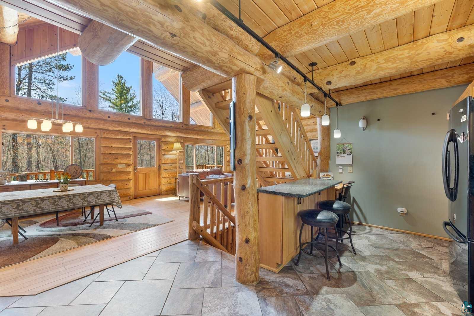 12957 West Ridge Road Ely, MN 55731 - Photo 4 of 41 Interior space featuring freestanding refrigerator, a wealth of natural light, wooden ceiling, and log walls