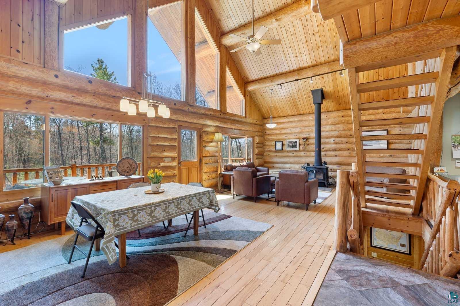 12957 West Ridge Road Ely, MN 55731 - Photo 8 of 41 Dining space featuring wood ceiling, high vaulted ceiling, log walls, beamed ceiling, and a wood stove