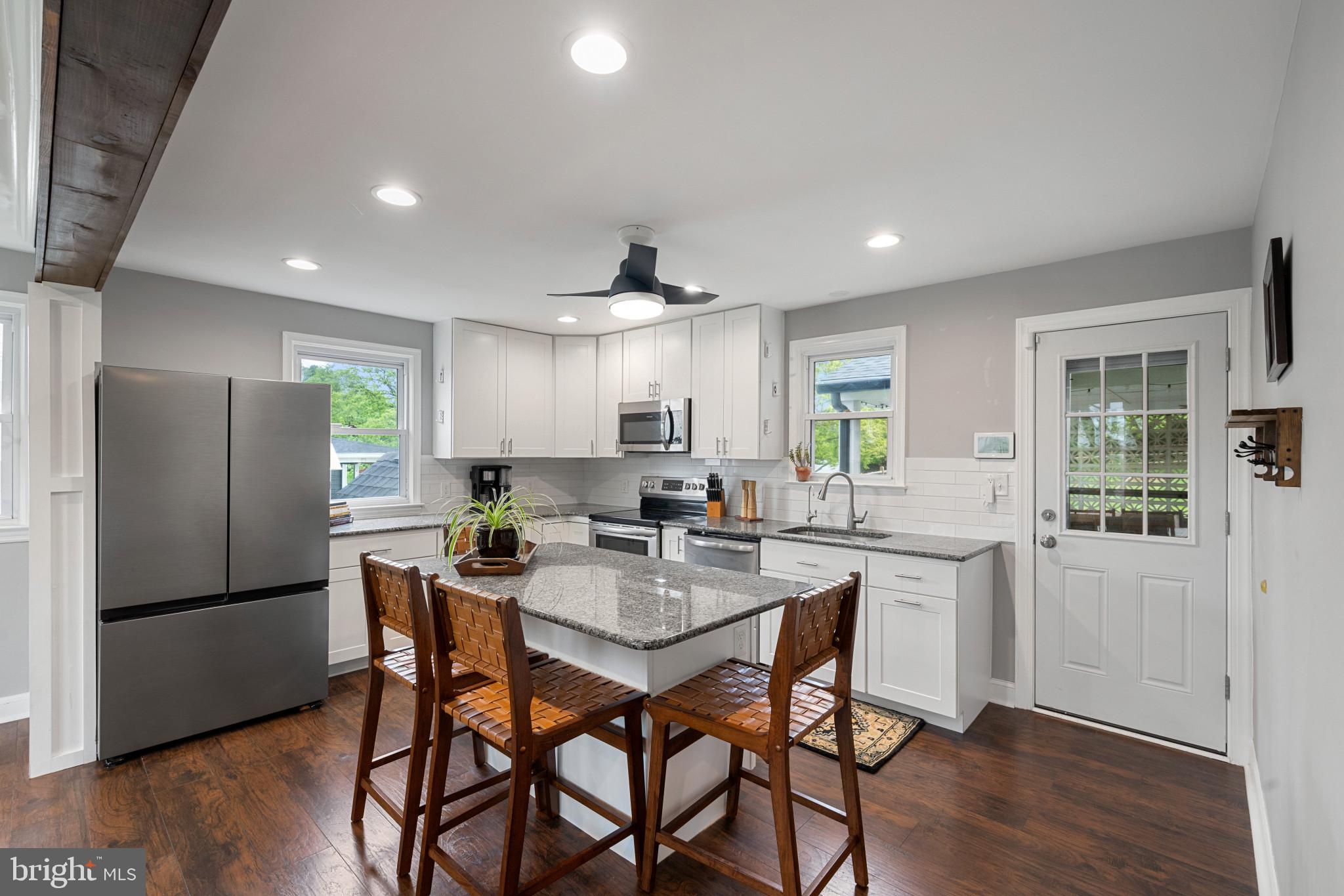 705 Longview Avenue Westminster, MD 21157 - Photo 8 of 30 a kitchen with stainless steel appliances granite countertop a dining table chairs refrigerator and cabinets