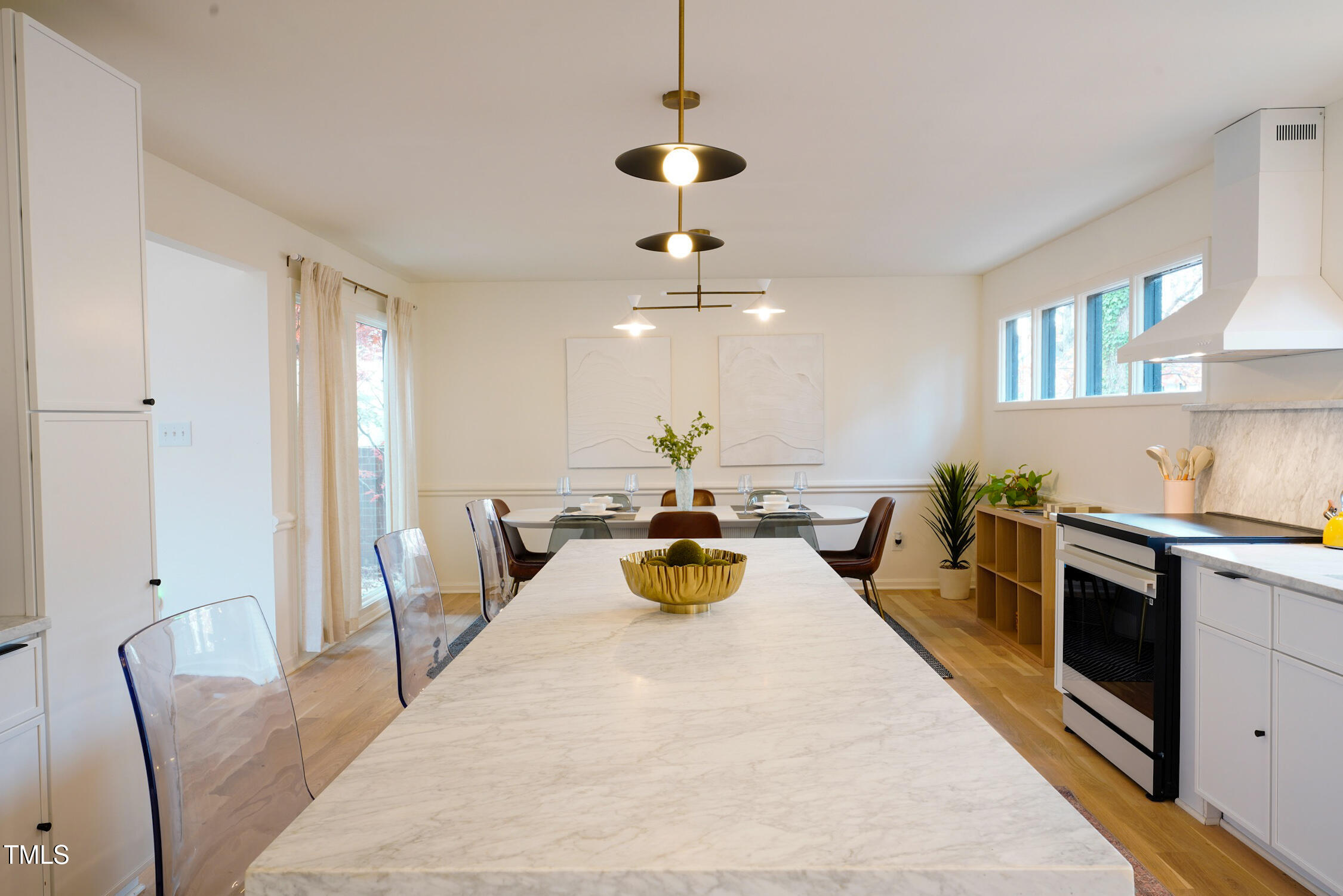 225 Woods Ream Drive Raleigh, NC 27615 - Photo 10 of 45 a kitchen with stainless steel appliances granite countertop a stove a refrigerator a sink a dining table and chairs with wooden floor