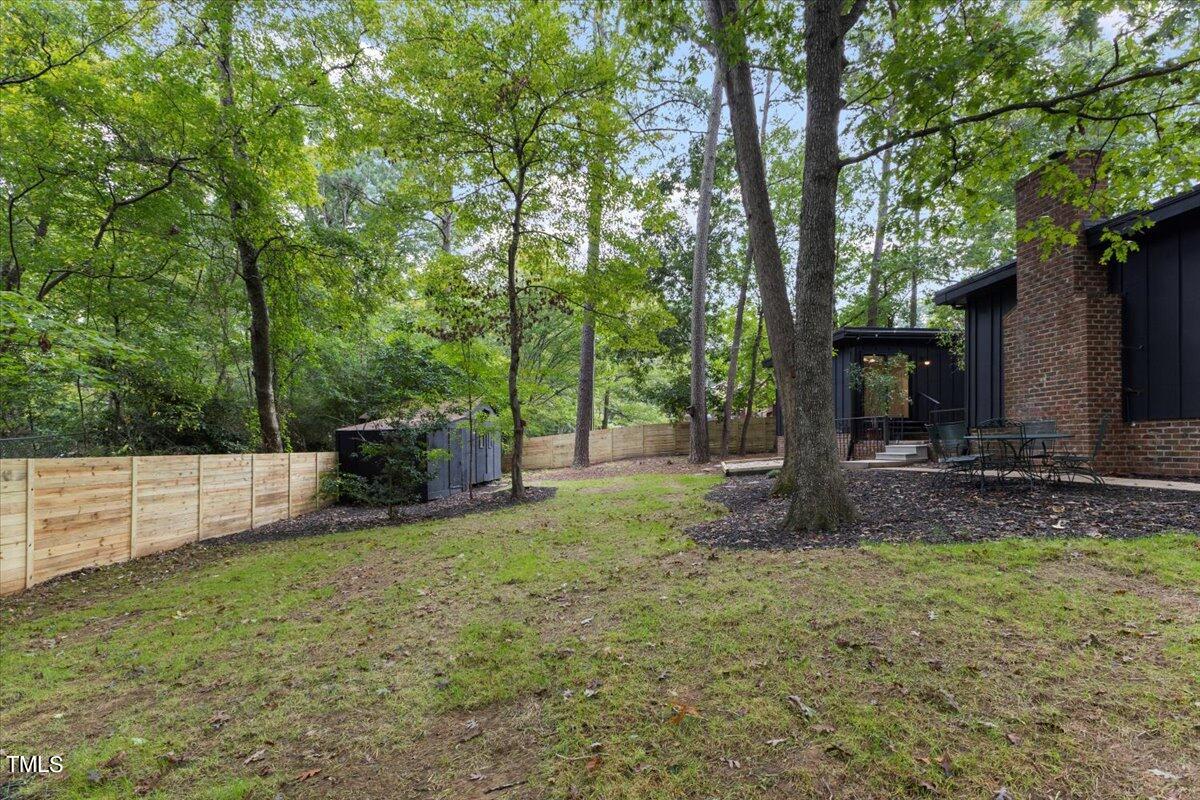 225 Woods Ream Drive Raleigh, NC 27615 - Photo 36 of 45 a view of a backyard with large trees and a barn