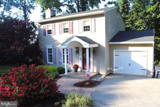 a front view of a house with a yard and a garden