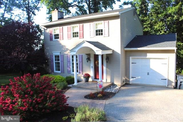 a front view of a house with a yard and a garden