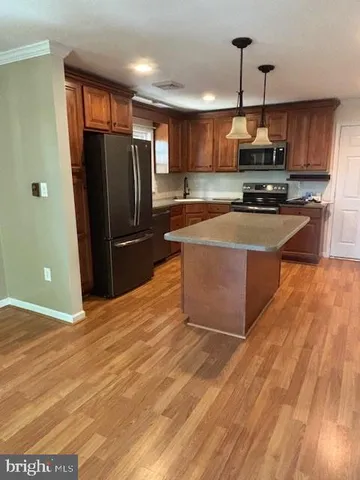 a kitchen with stainless steel appliances granite countertop a refrigerator a stove and a sink