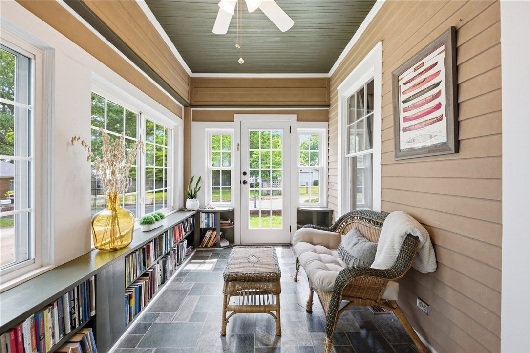 1104 Power Street Anderson, SC 29621 - Photo 5 of 34 A naturally illuminated sunroom featuring extensive window-lined bookshelves and a central ceiling fan.