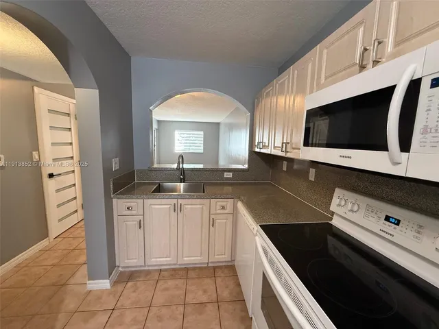 a kitchen with stainless steel appliances a sink stove and cabinets