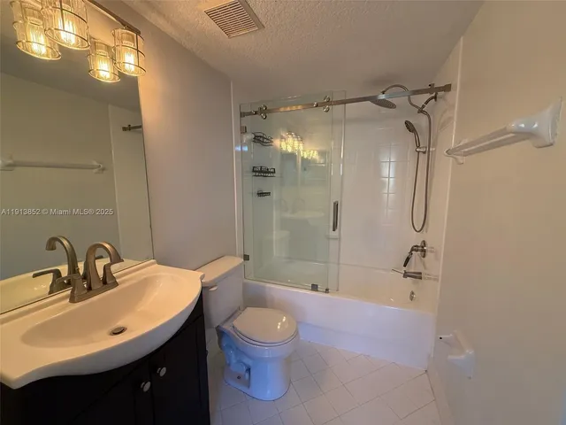 a bathroom with a sink a toilet a mirror and shower