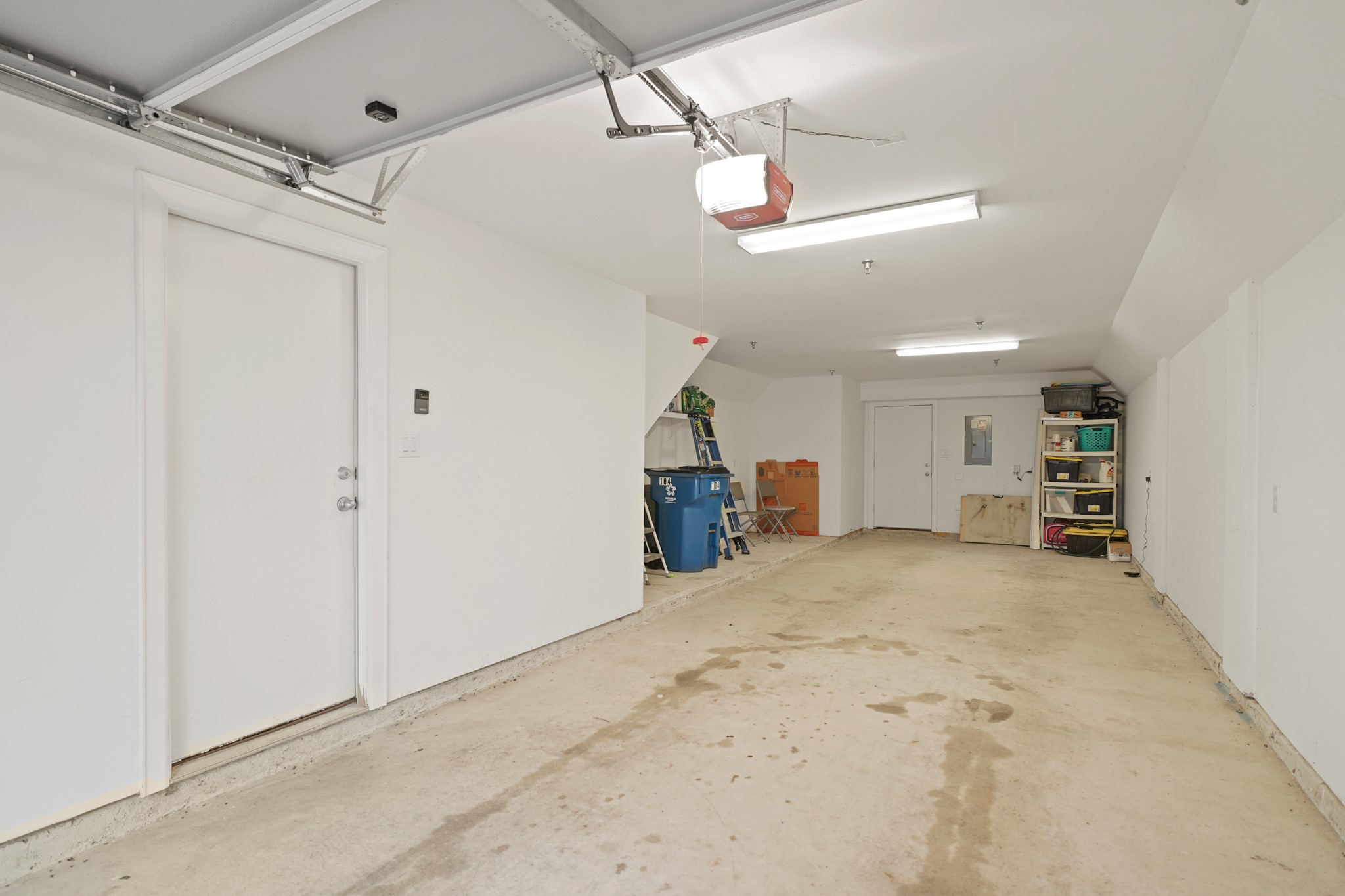 8705 Bryam Street, Unit 104 Houston, TX 77061 - Photo 16 of 16 Spacious tandem 2-car garage with overhead lighting and room for storage – ideal for tools, bins, or bikes.