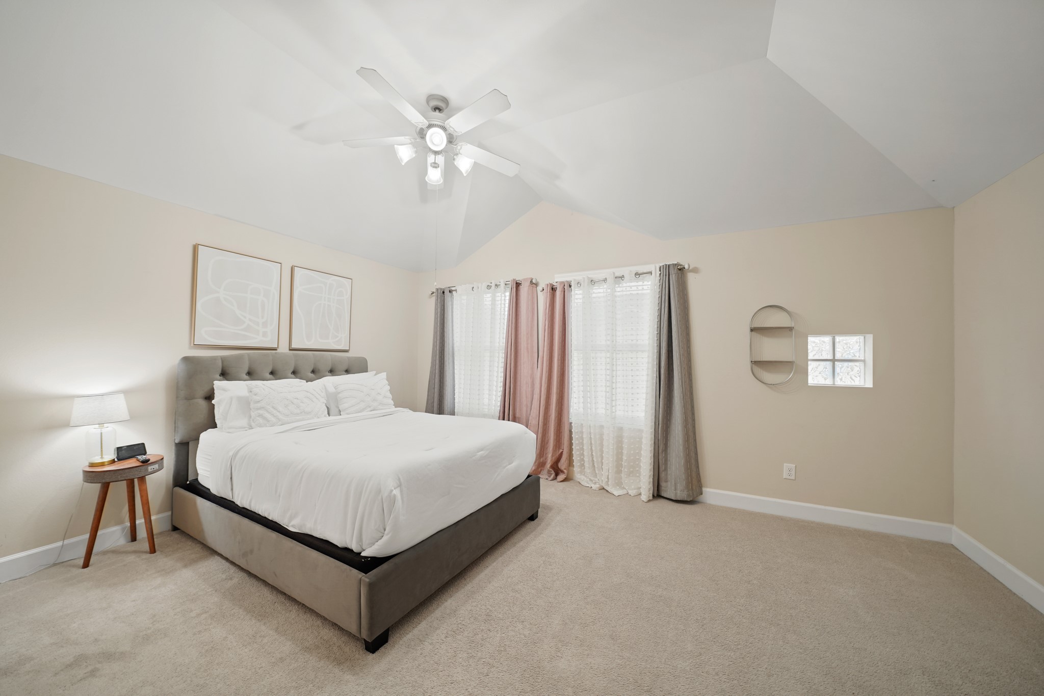 8705 Bryam Street, Unit 104 Houston, TX 77061 - Photo 9 of 16 Retreat to a generous primary suite on the third floor with vaulted ceilings, plush carpet, and ensuite access to a spa-style bath.