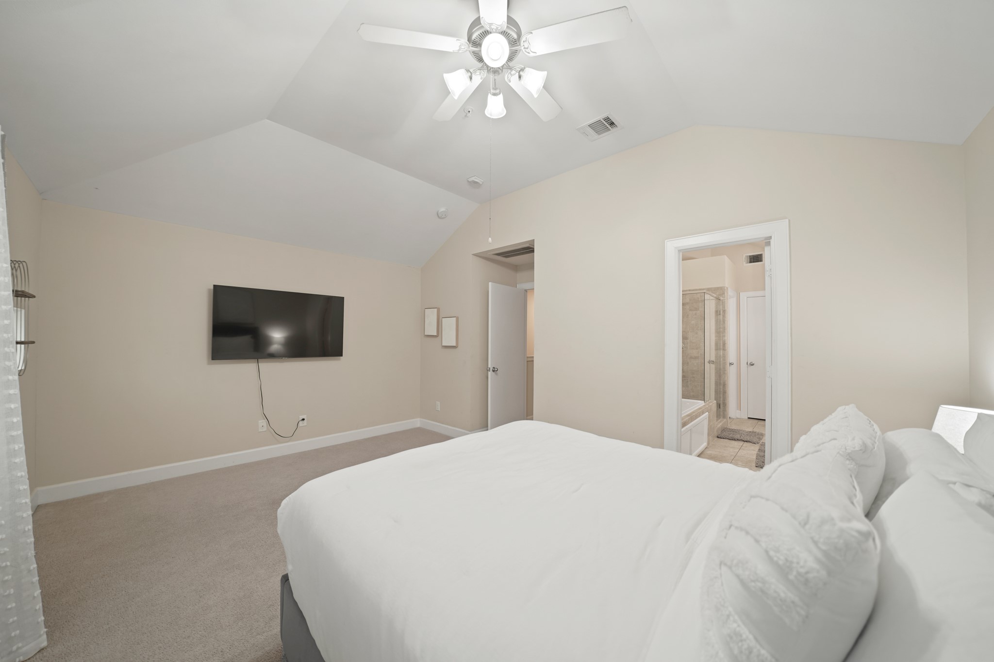 8705 Bryam Street, Unit 104 Houston, TX 77061 - Photo 10 of 16 Peaceful and inviting, the primary suite features soft carpeting, natural light through a large window, a ceiling fan for comfort, and a neutral palette ready for your personal touch. A perfect retreat at the end of the day.