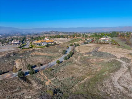 a view of a dry yard with wooden fence