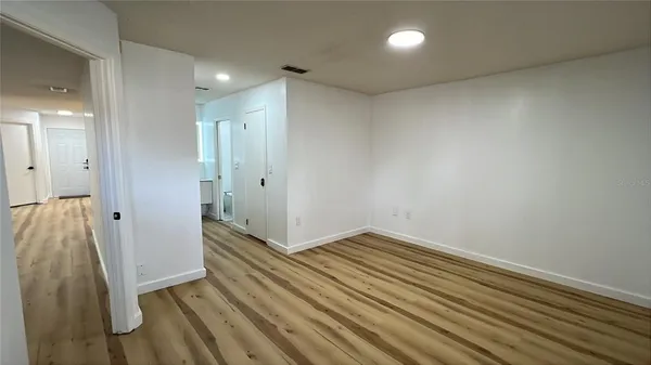 a view of a hallway with wooden floor