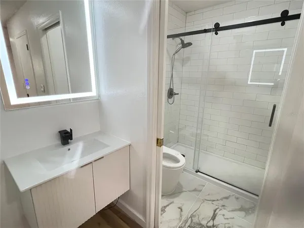 a bathroom with a sink toilet and shower