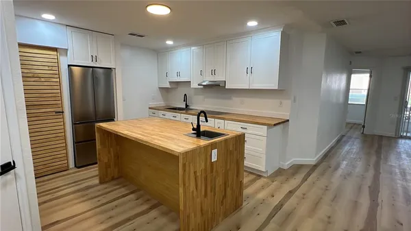 a kitchen with a sink a refrigerator and cabinets