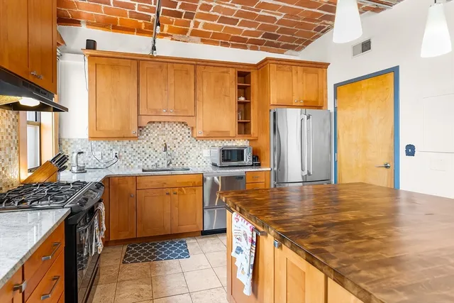 a kitchen with stainless steel appliances granite countertop a sink stove and refrigerator