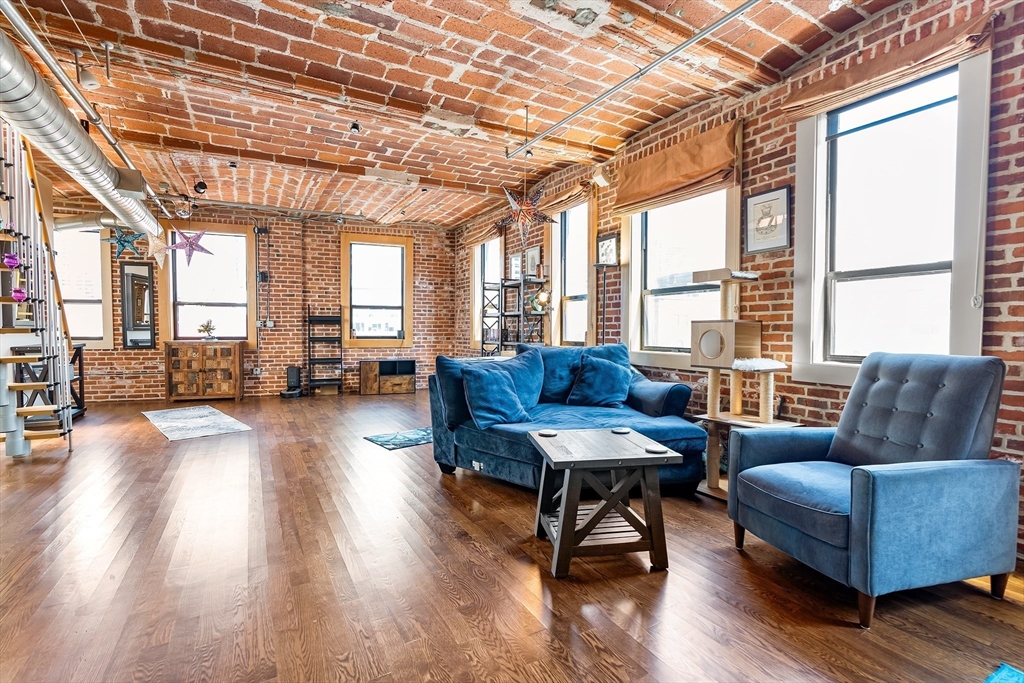 121-123 Beach Street, Unit 801 Boston, MA 02111 - Photo 7 of 28 a living room with furniture wooden floor and a large window