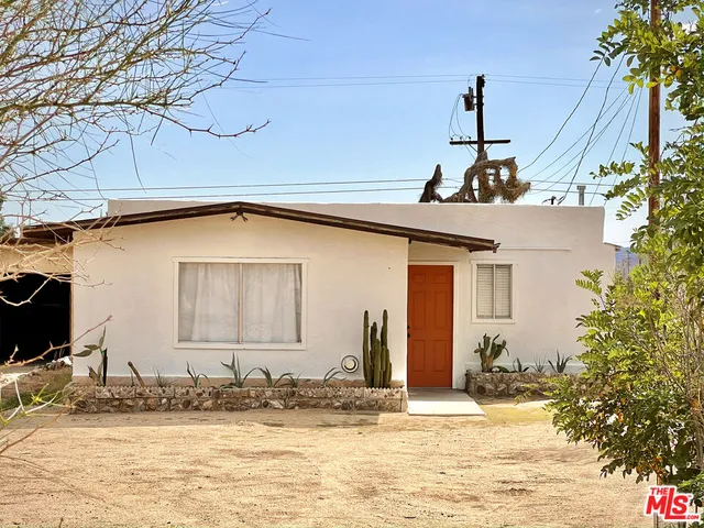 a view of an empty room with window and chandelier fan
