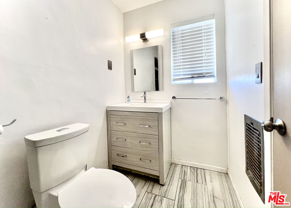 6391 Ruth Drive Yucca Valley, CA 92284 - Photo 55 of 56 a bathroom with a toilet a sink a mirror and a window