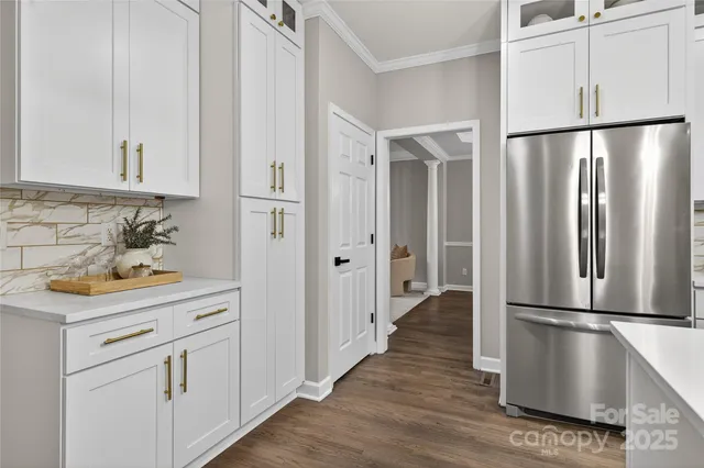 a view of a kitchen with wooden floor and electronic appliances
