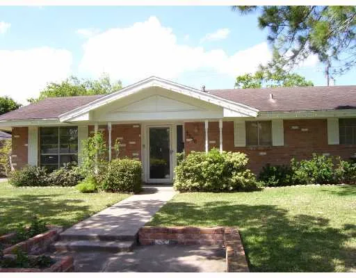 a front view of a house with a yard and potted plants