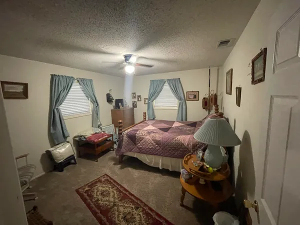 a spacious bedroom with a bed large mirror and furniture