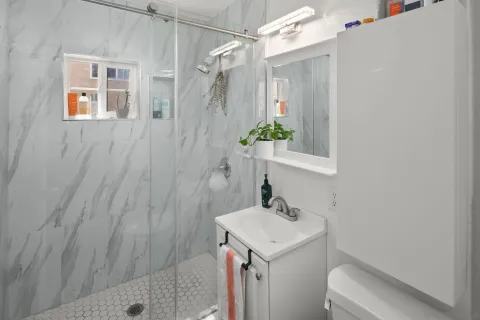a bathroom with a sink and mirror with toilet