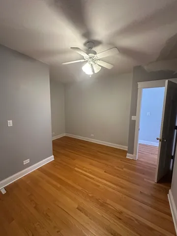a view of a room with wooden floor and a ceiling fan