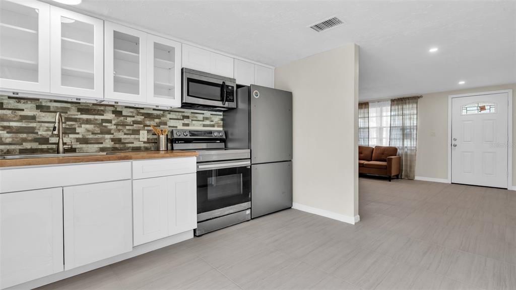 14832 Atlantic Avenue Hudson, FL 34667 - Photo 13 of 37 a kitchen with white cabinets and stainless steel appliances