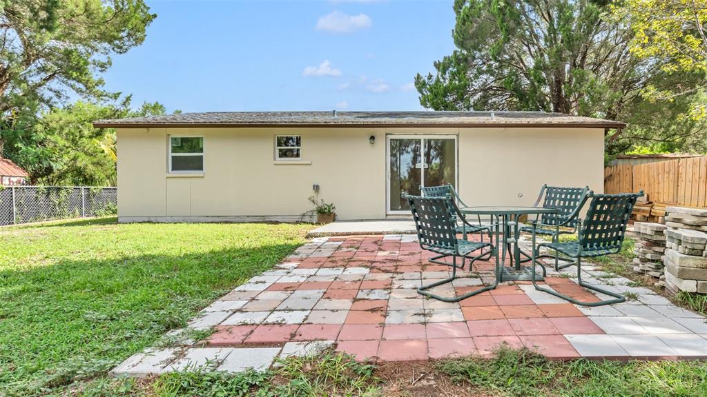 14832 Atlantic Avenue Hudson, FL 34667 - Photo 19 of 37 a view of a patio with table and chairs with wooden fence and plants