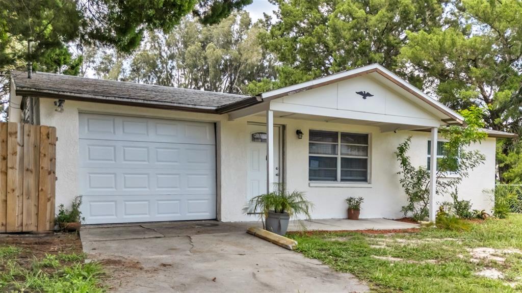 14832 Atlantic Avenue Hudson, FL 34667 - Photo 4 of 37 a front view of a house with a yard and garage