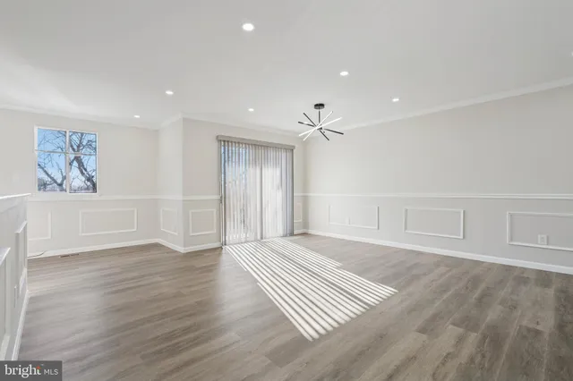 an empty room with wooden floor and window