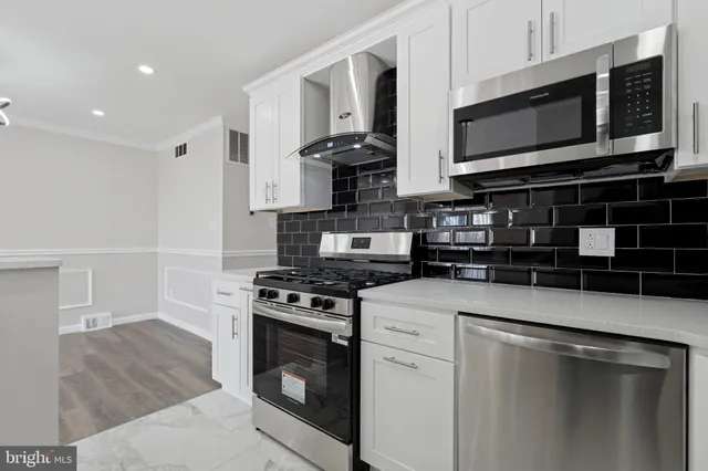 a kitchen with stainless steel appliances granite countertop a stove a microwave and a refrigerator