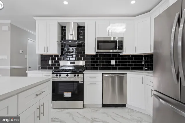 a kitchen with stainless steel appliances granite countertop a stove refrigerator sink and microwave