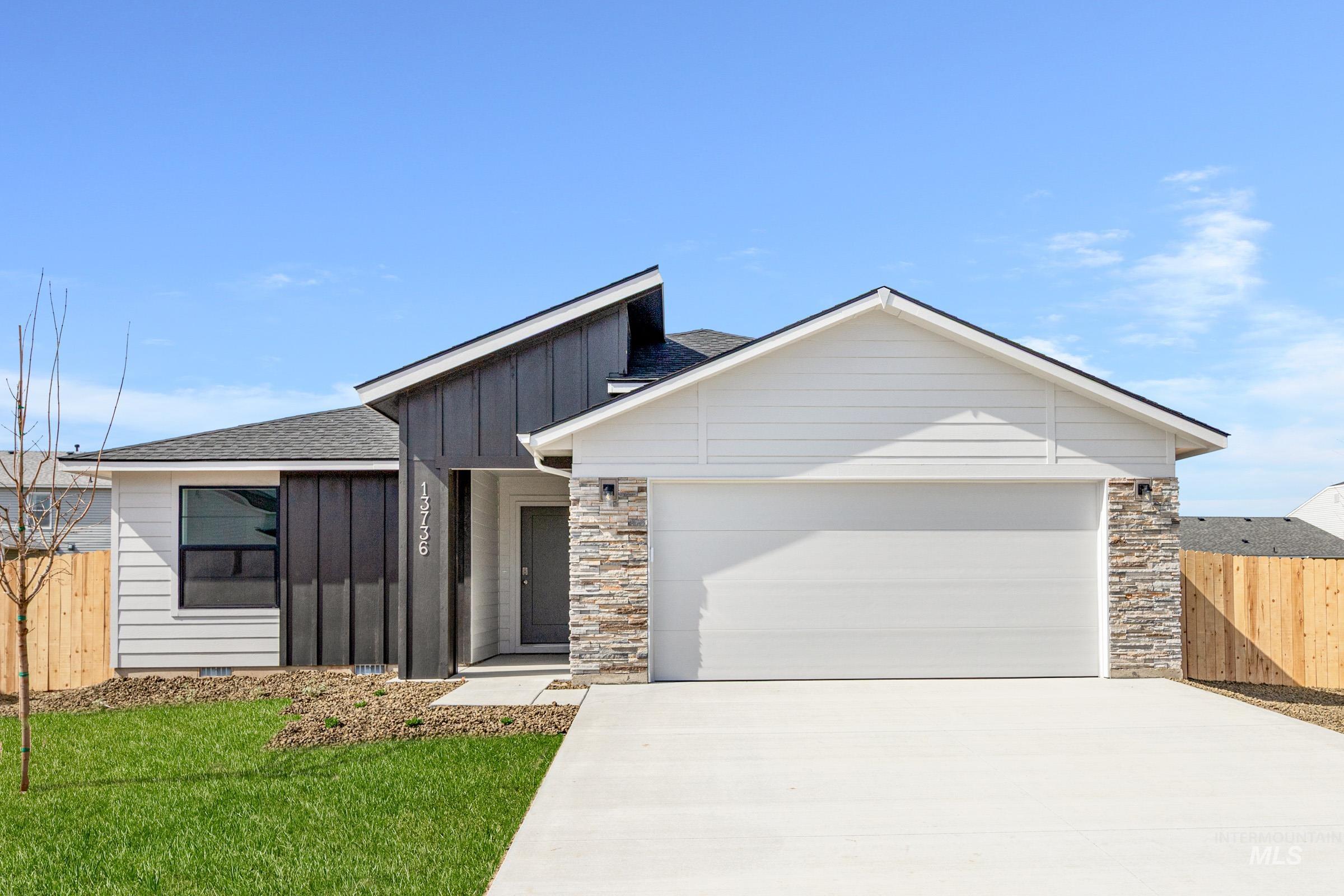 13736 Inman Court Caldwell, ID 83607 - Photo 1 of 20 View of front of property with board and batten siding, a garage, concrete driveway, and stone siding