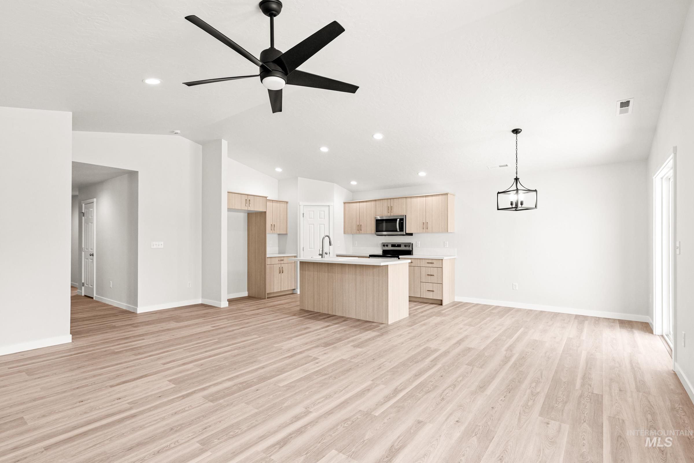 13736 Inman Court Caldwell, ID 83607 - Photo 20 of 20 Kitchen with open floor plan, a kitchen island with sink, light countertops, ceiling fan, and light wood finish cabinetry