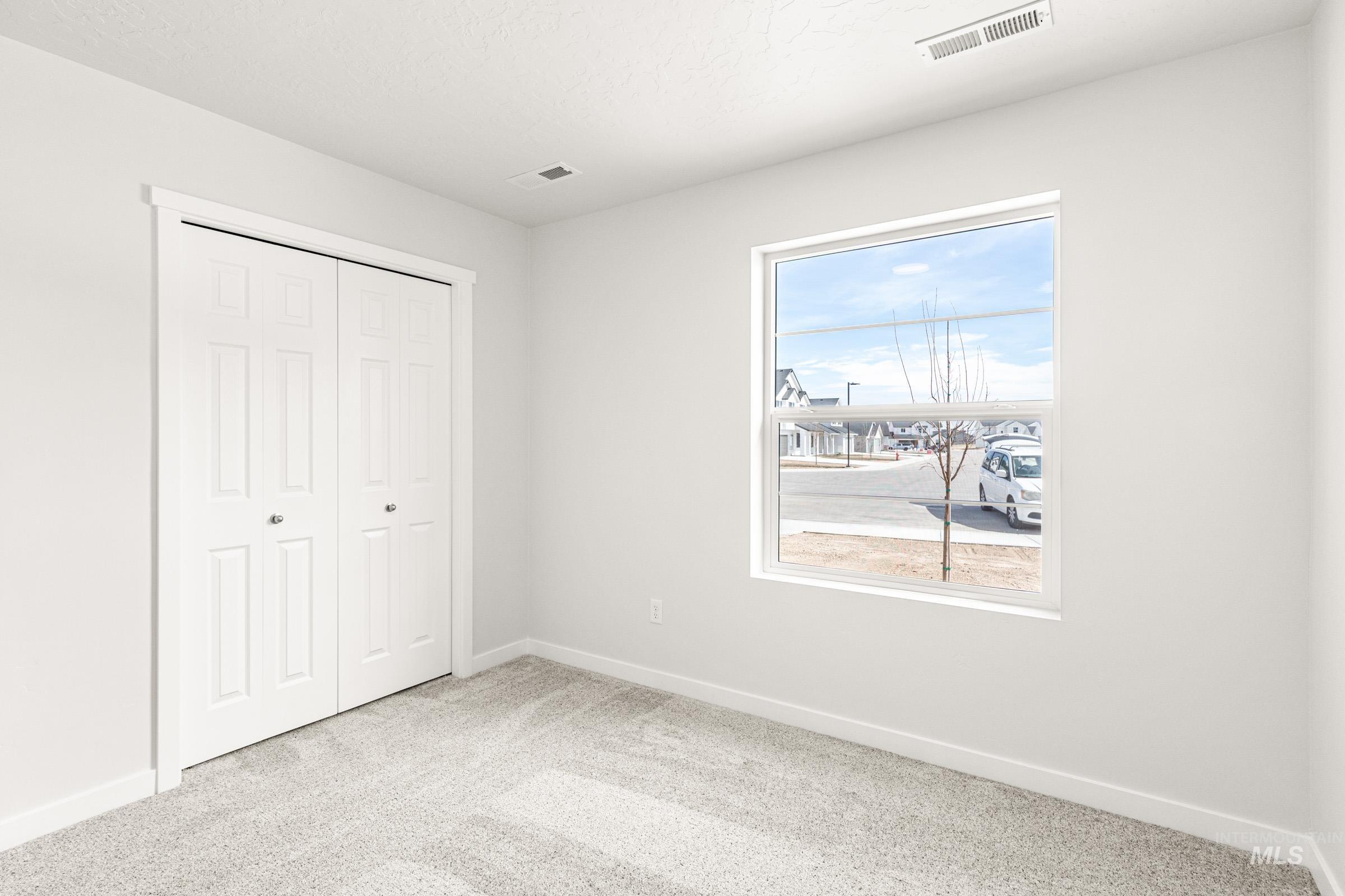 13736 Inman Court Caldwell, ID 83607 - Photo 10 of 20 Unfurnished bedroom with light carpet and a closet