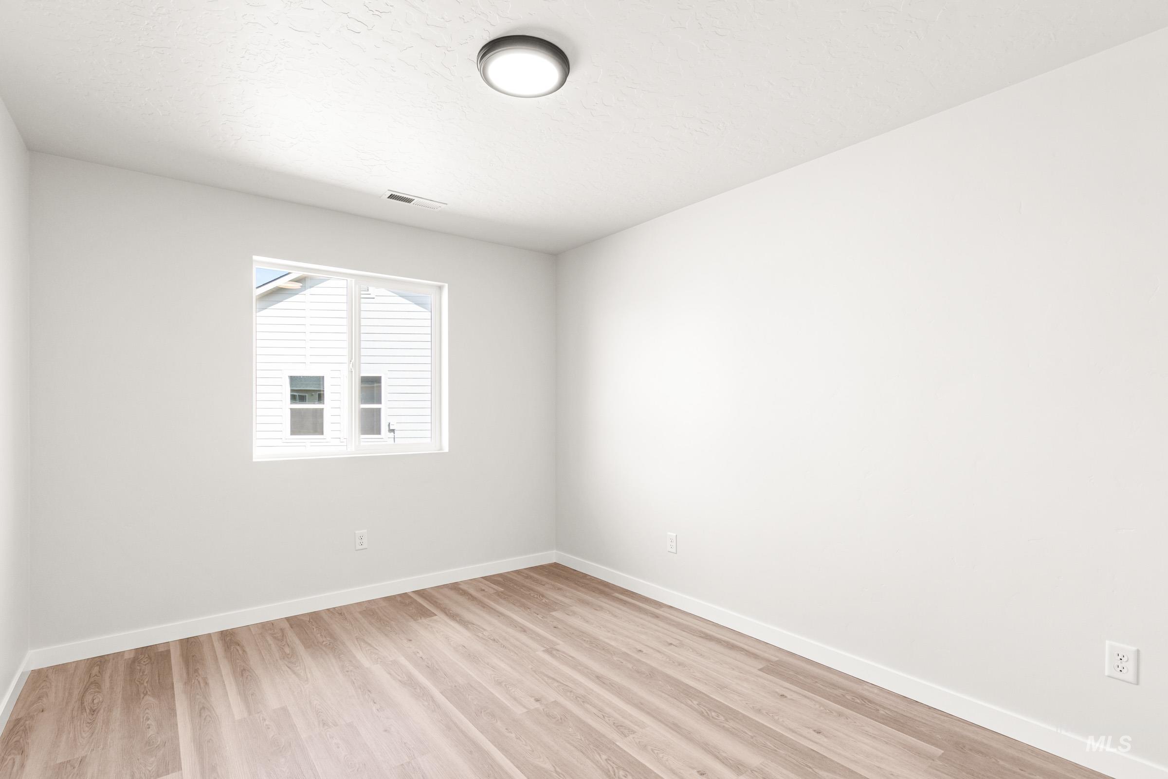 13736 Inman Court Caldwell, ID 83607 - Photo 14 of 20 Empty room with light wood-type flooring and baseboards
