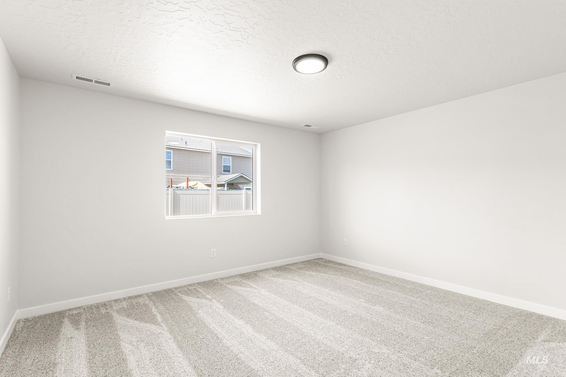 13736 Inman Court Caldwell, ID 83607 - Photo 15 of 20 Unfurnished room with light colored carpet and a textured ceiling