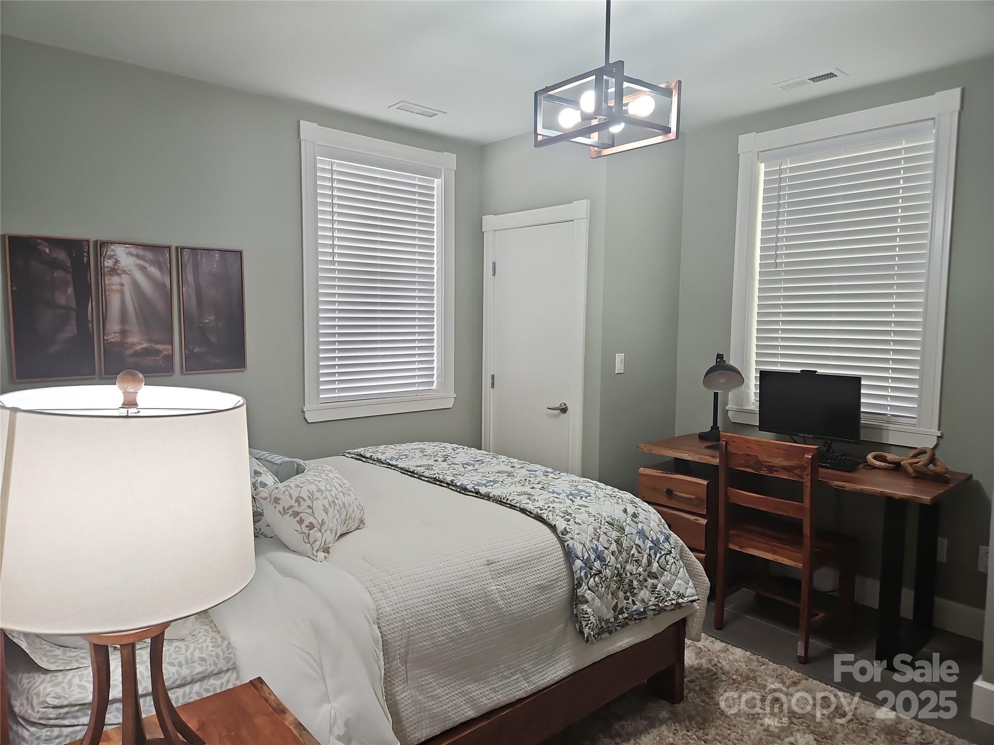 2905 Medlin Road Monroe, NC 28112 - Photo 22 of 39 a bedroom with a bed and a chandelier