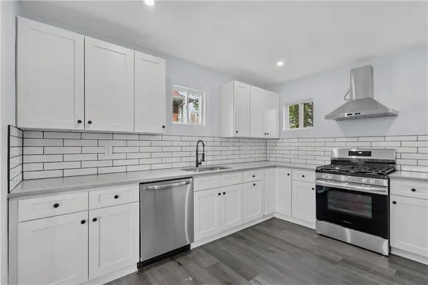 a kitchen with a sink cabinets and wooden floor