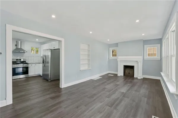 a view of an empty room with wooden floor and closet