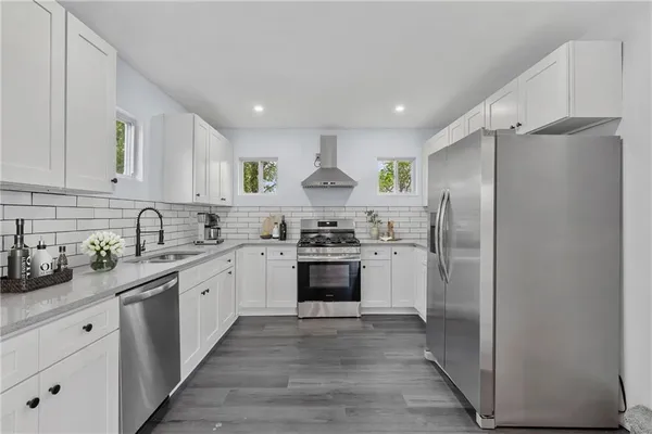 a kitchen with stainless steel appliances granite countertop a sink stove and refrigerator