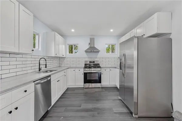 a kitchen with stainless steel appliances granite countertop a stove a refrigerator and a refrigerator