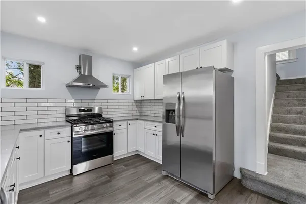 a kitchen with white cabinets stainless steel appliances and sink