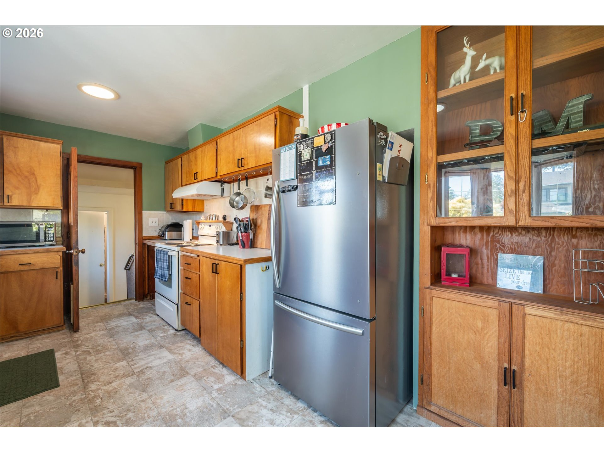 1789 14th Street North Bend, OR 97459 - Photo 15 of 43 a kitchen with stainless steel appliances kitchen island granite countertop a refrigerator a stove and a sink