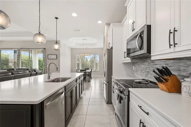 a kitchen with stainless steel appliances a sink a stove and a wooden floor