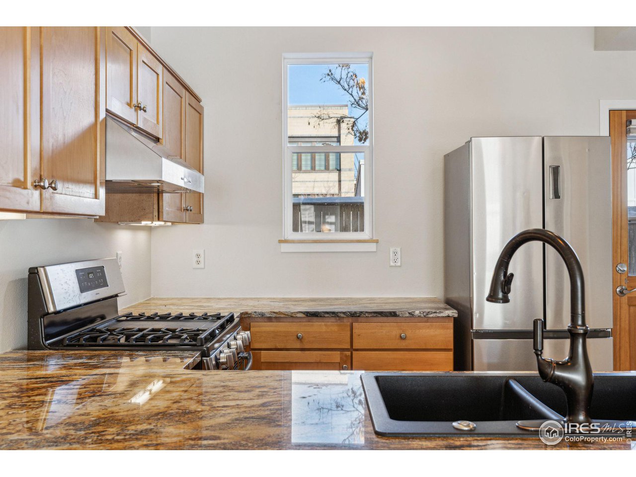 1351 Yellow Pine Avenue Boulder, CO 80304 - Photo 12 of 34 a kitchen with stainless steel appliances granite countertop a stove a refrigerator a sink a counter space and cabinets